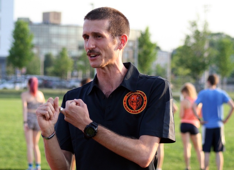 Coach Chris Knighton teaching at a private adult lesson at an outdoor track.