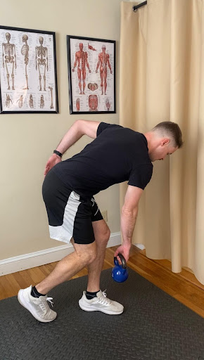 Alex Burke, PT demonstrating how to perform a kickstand RDL exercise to lengthen and strengthen hamstrings.