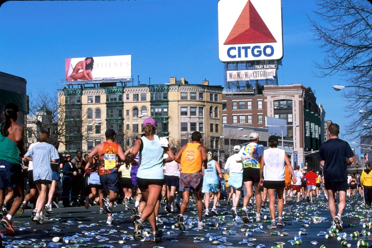 Athletes Running at Mile 25 of the Boston Marathon, under the CITGO sign in Kenmore Square.